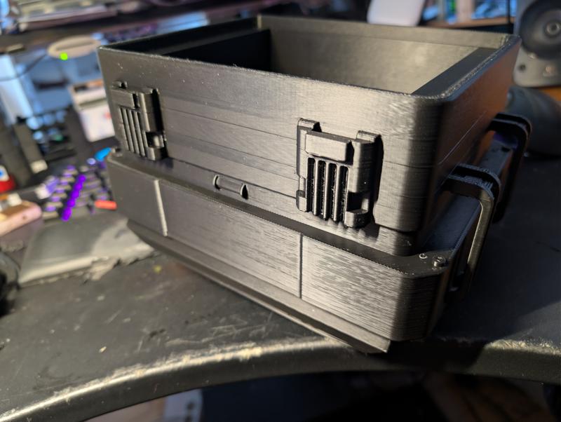 Black 3D-printed instrument case shell without paint, showing moulded latch details, a printed hinge and visible layer lines