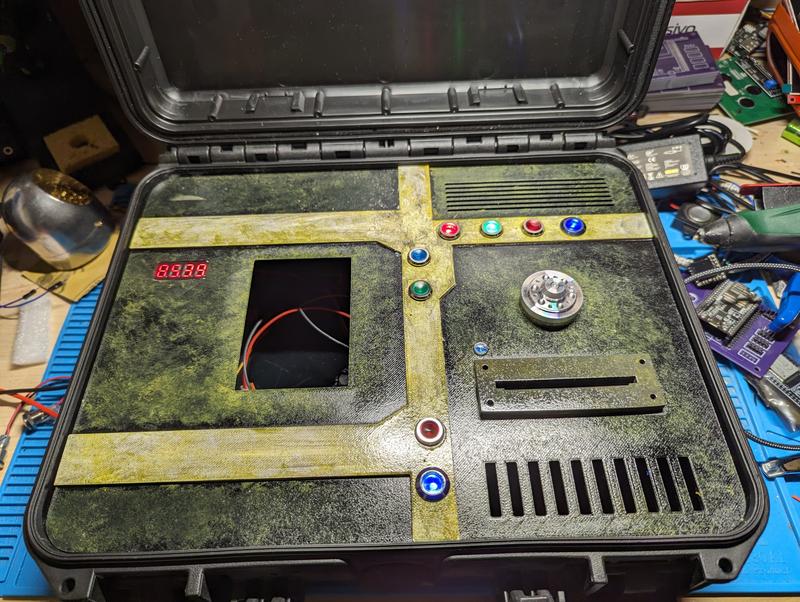 The same panel after painting in weathered green and yellow, mounted in the case with the four-digit readout lit and the main display cutout still open